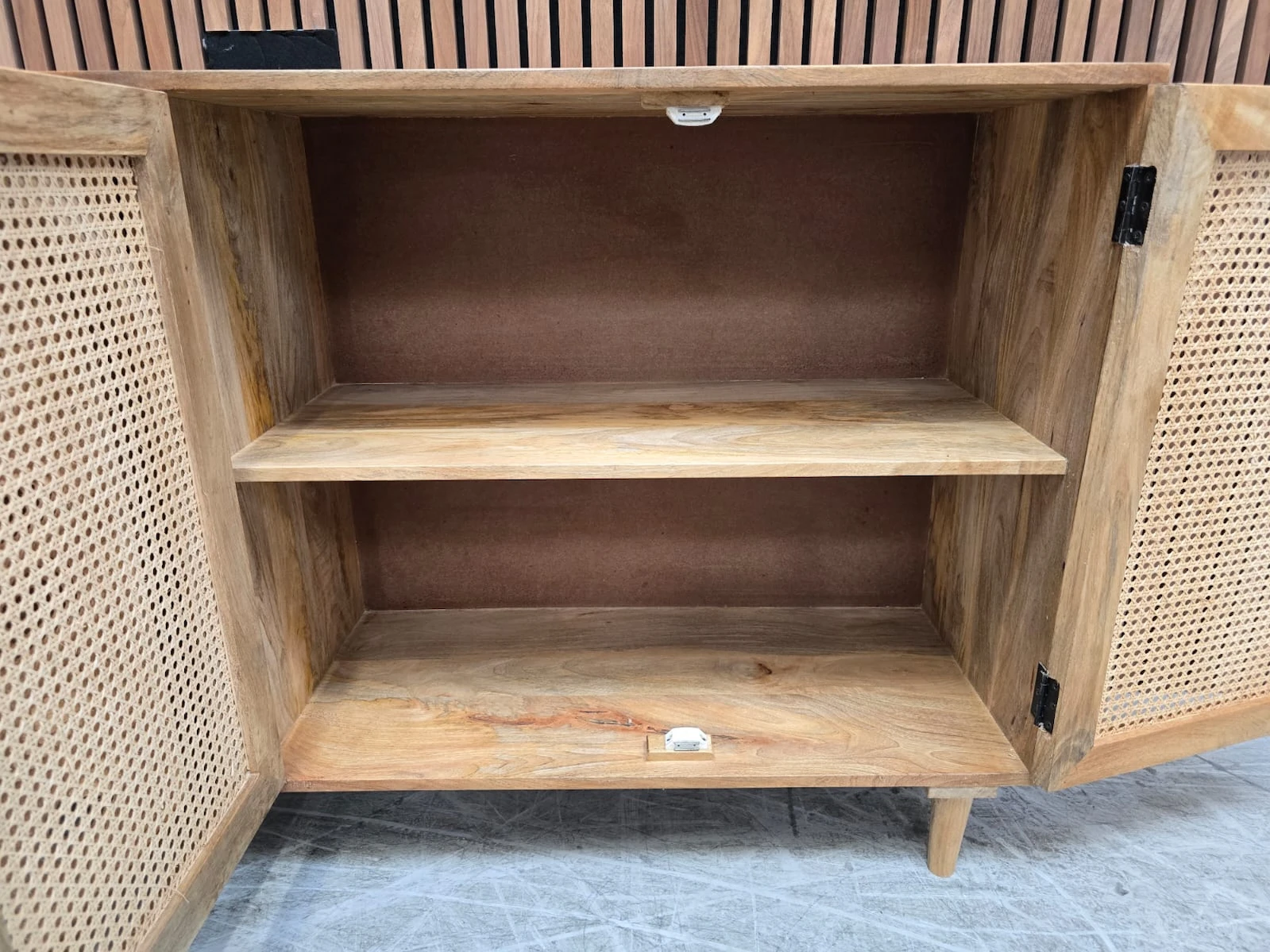 inside the cupboard space of the sideboard which includes and shelf